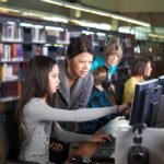 Qué funciones tiene un bibliotecario en instituciones educativas a distancia bibliotecario-ayudando-estudiantes-en-biblioteca-digital