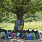 Qué es la Escuela Nueva Juan Mantovani y dónde está ubicada escuela-rural-con-ninos-aprendiendo-al-aire-libre