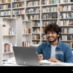 Cómo Acceder y Usar El Campus Virtual De La UNC estudiante-usando-laptop-en-biblioteca-universitaria