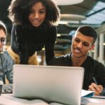 Cómo acceder y aprovechar el Campus Virtual UNC para cursos estudiantes-usando-laptop-en-biblioteca-universitaria