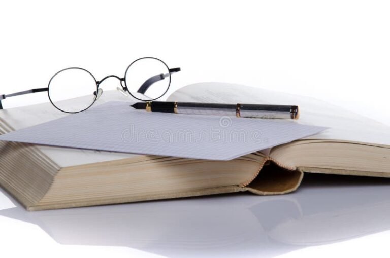 libro abierto con pluma y gafas