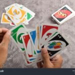 Cuáles Son Las Reglas Básicas Para Jugar Al Uno manos-jugando-cartas-del-juego-uno