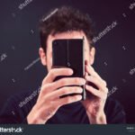 A Quién Pertenece Este Celular Y Cómo Puedo Identificarlo manos-sosteniendo-un-celular-visto-de-frente