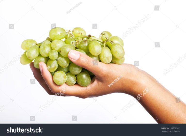 manos sosteniendo uvas sobre contratos financieros