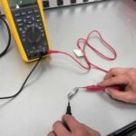 Cómo Medir Corriente con un Multímetro de Forma Segura y Precisa manos-usando-multimetro-en-circuito-electrico