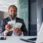 Cómo Realizar El Pago De Sueldos En Santa Fe Según La Ley Vigente persona-contando-billetes-sobre-escritorio-oficina