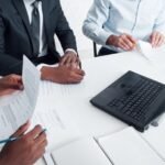 Cómo acceder al bono de Anses para trabajo informal persona-entregando-documentos-en-oficina-publica