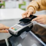 persona-pagando-con-tarjeta-en-telefono-movil