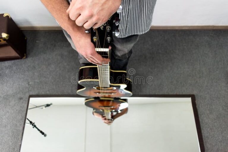 persona reflexionando junto a una guitarra acustica