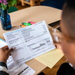 Cómo Hacer Para Anotarse en el Subsidio de Luz y Gas en Argentina persona-rellenando-formulario-con-electricidad-y-gas